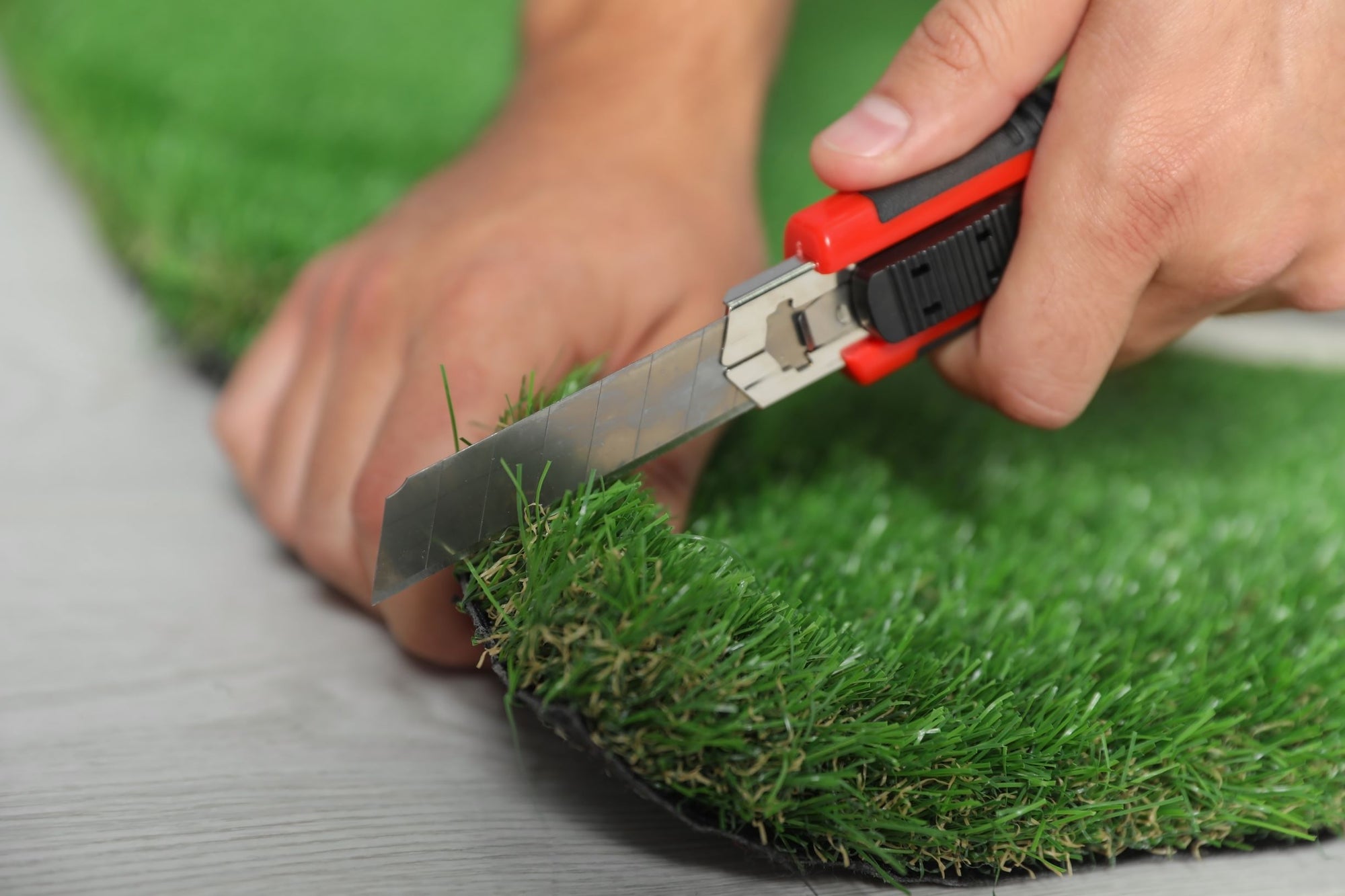 Photo of artificial turf being cut for fitting